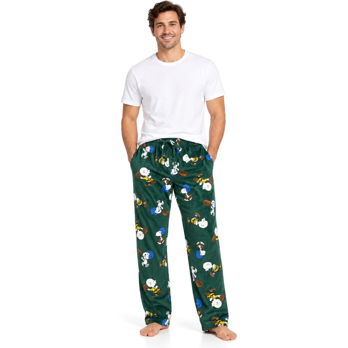 Smiling man in a white tee and the green Peanuts Good Sport lounge pants on white