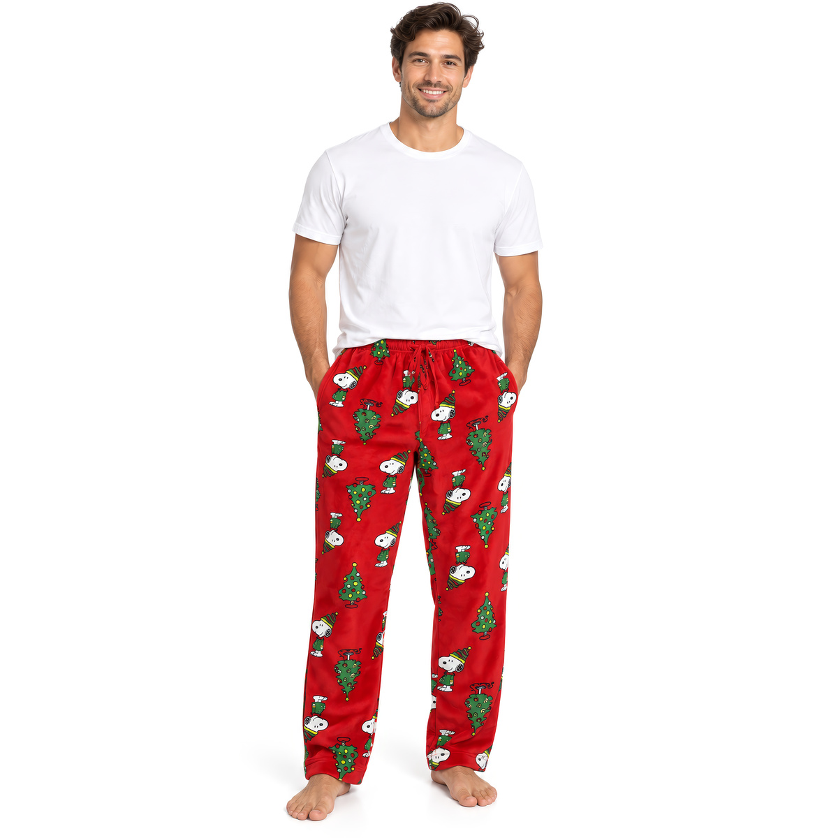 Smiling man in a white tee and the red Peanuts Perfect Tree lounge pants on white