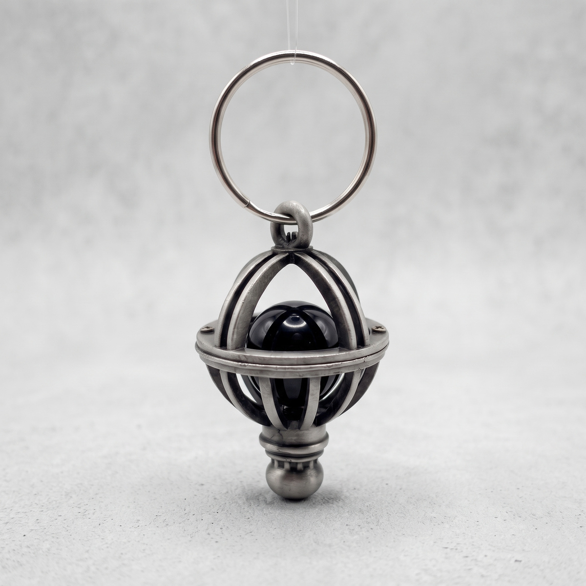 Orion's Belt charm keychain on a light grey textured background