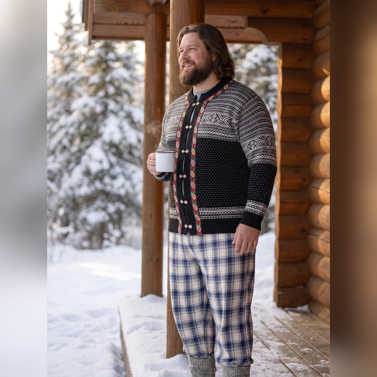 Man holding a mug on a snowy cabin porch wearing the Thunder God knitted cardigan
