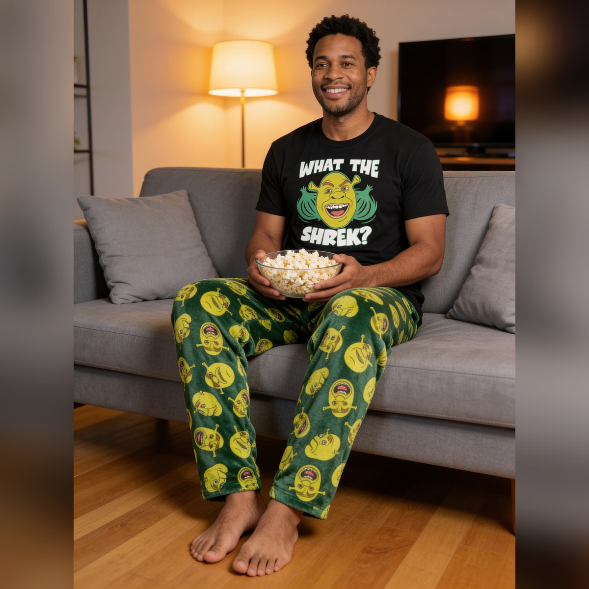 Man relaxing on a sofa with popcorn in the Shrek What the Shrek pajama loungewear set