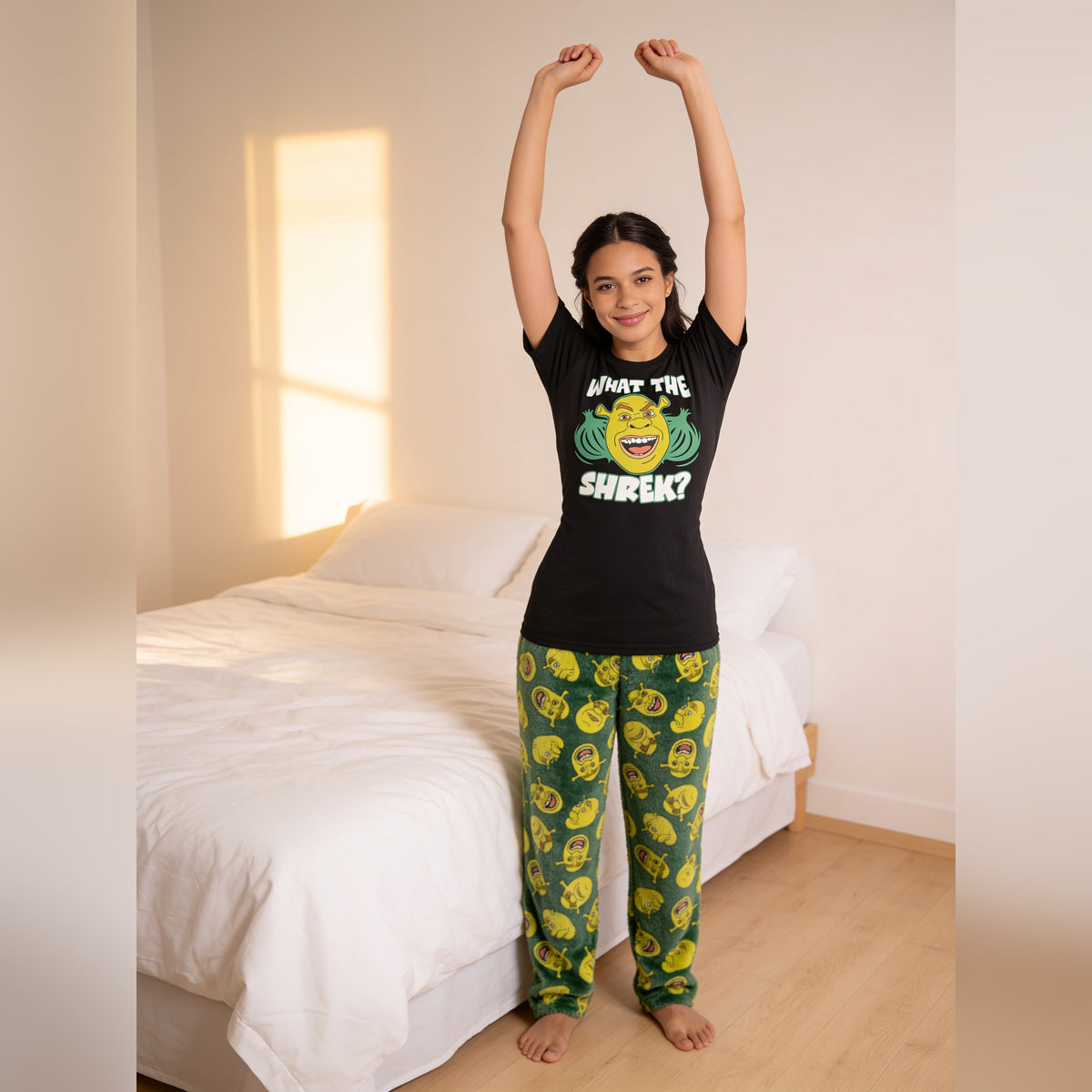 Woman stretching beside a bed in the Shrek What the Shrek pajama set