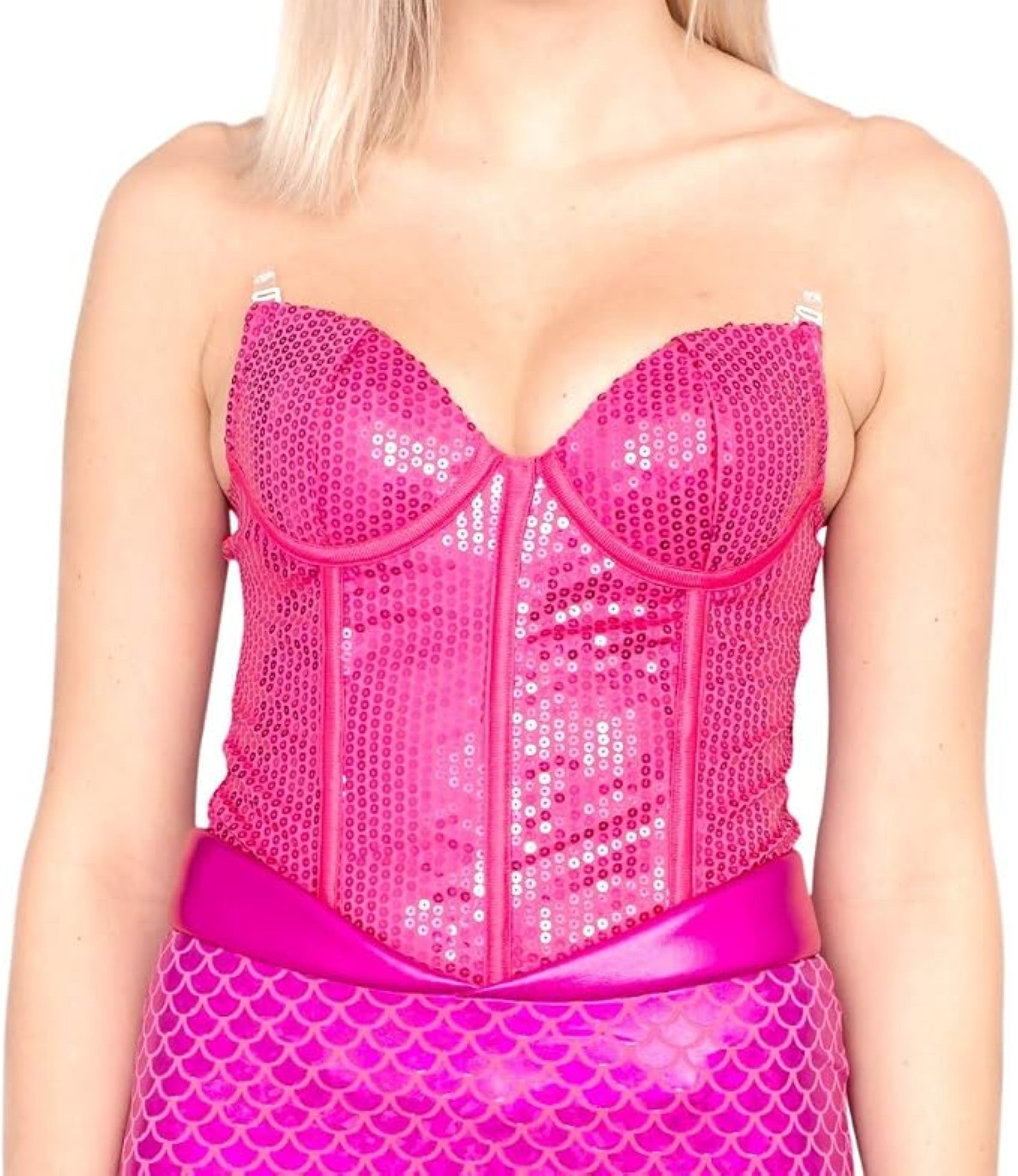 A close-up of a model wearing a bright pink sequined corset top with a matching pink scale-patterned skirt against a plain white background.
