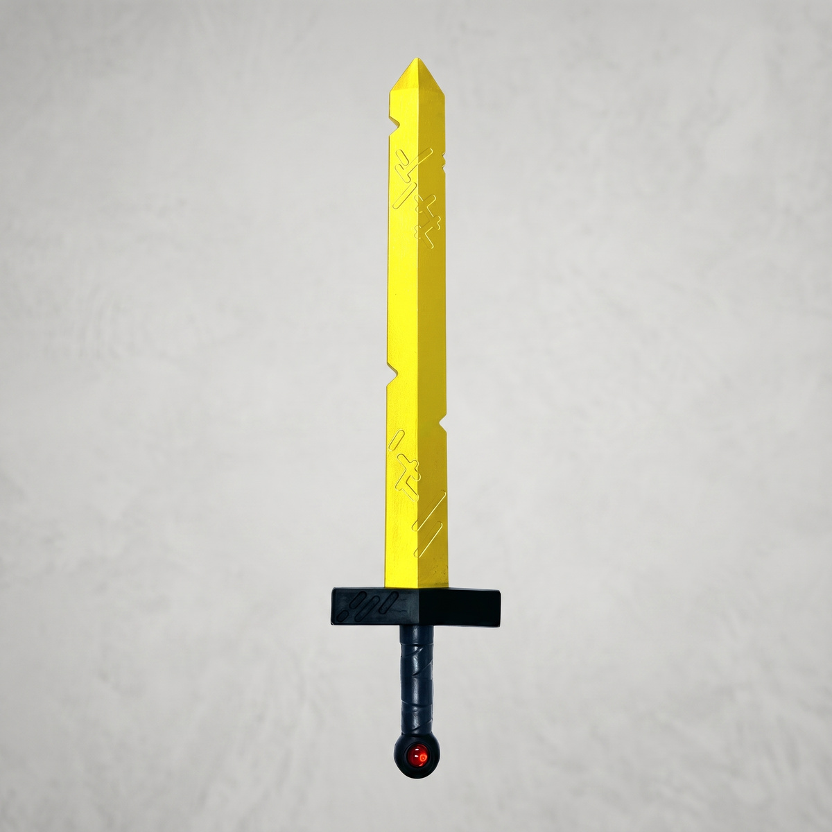 Gold and black Finn prop sword standing upright on a light textured background